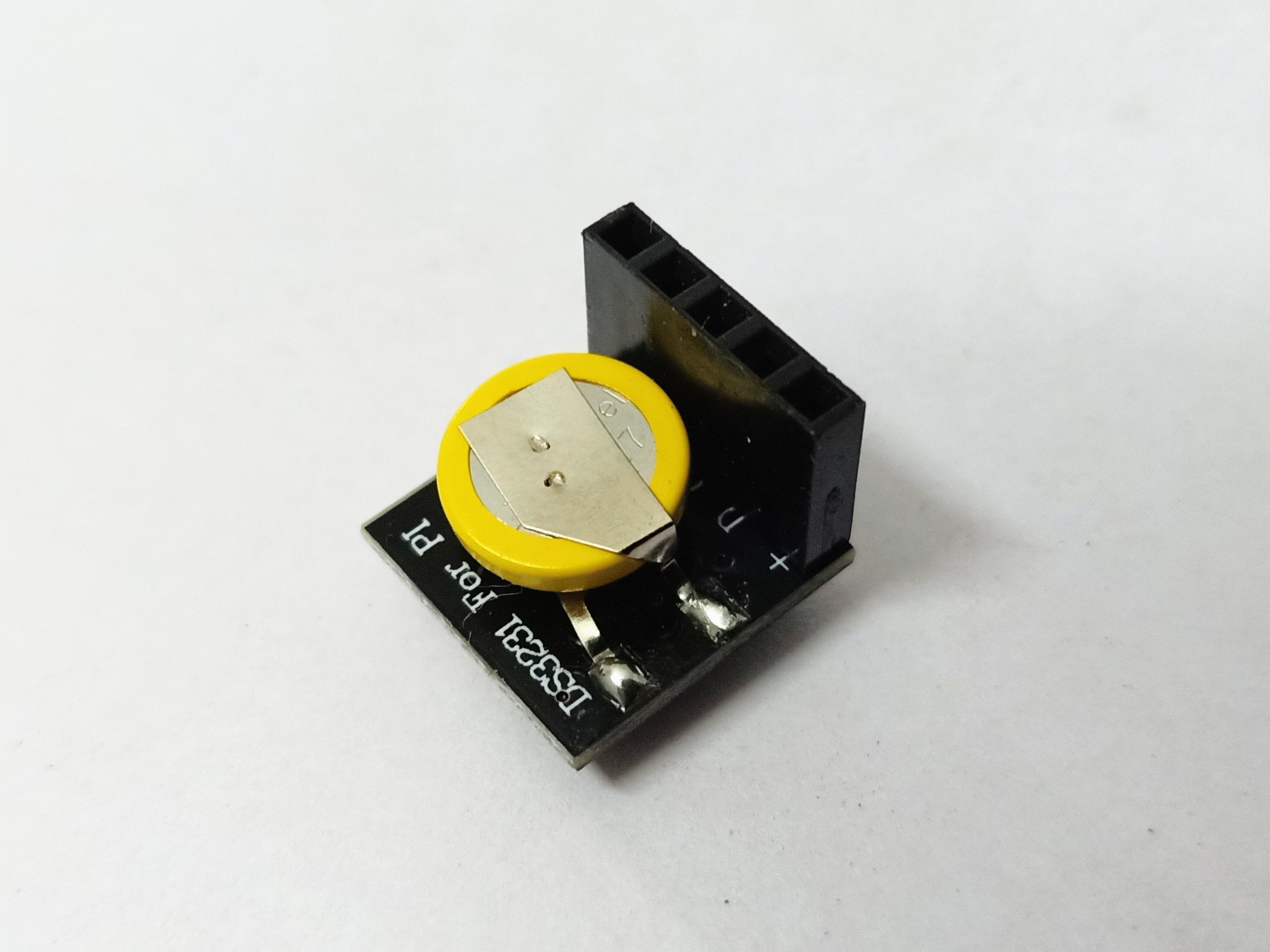 A DS3231 real-time-clock breakout module, ~25 × 15 mm with a CR2032 coin cell on the rear. Four pins: VCC, GND, SDA, SCL — connect to the PicoCalc's 3 V3 + I²C bus on the side-header. Battery life:…
