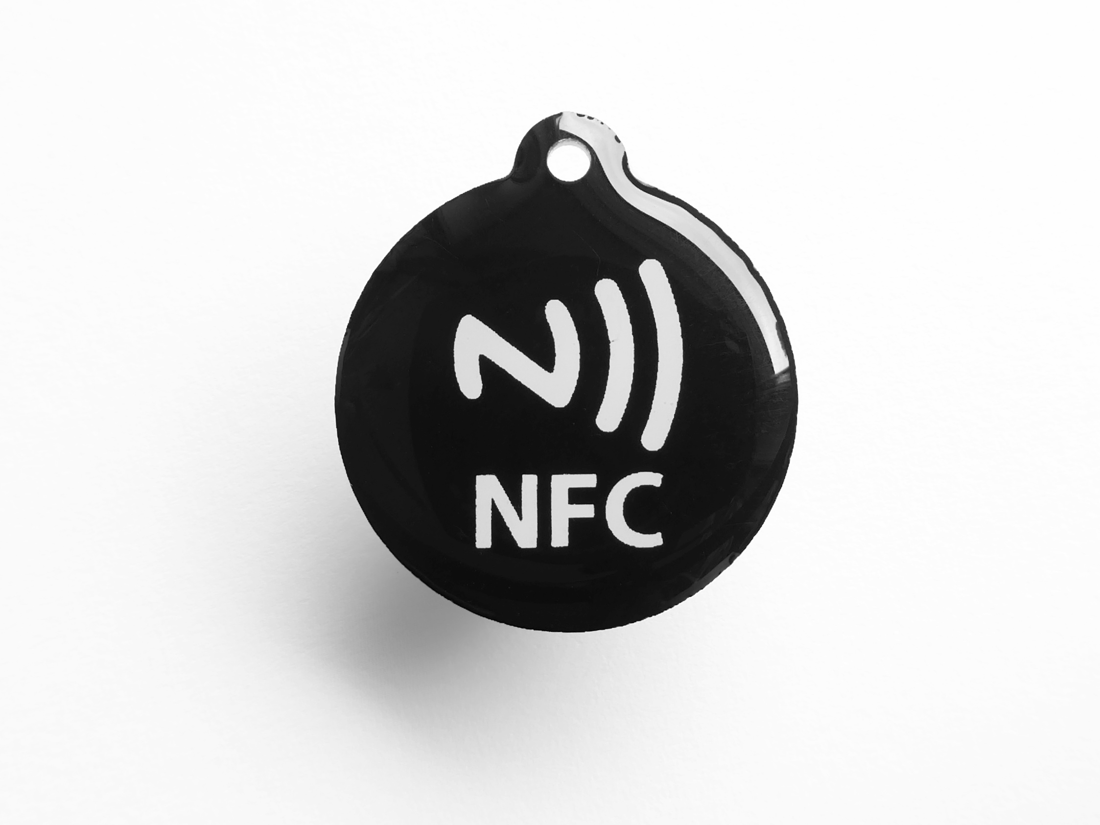 An NFC tag chip in its glass-encapsulated package — the physical form factor that ships in NFC stickers, embedded in lamps and posters, and in the long tail of NFC-enabled consumer products. The ch…